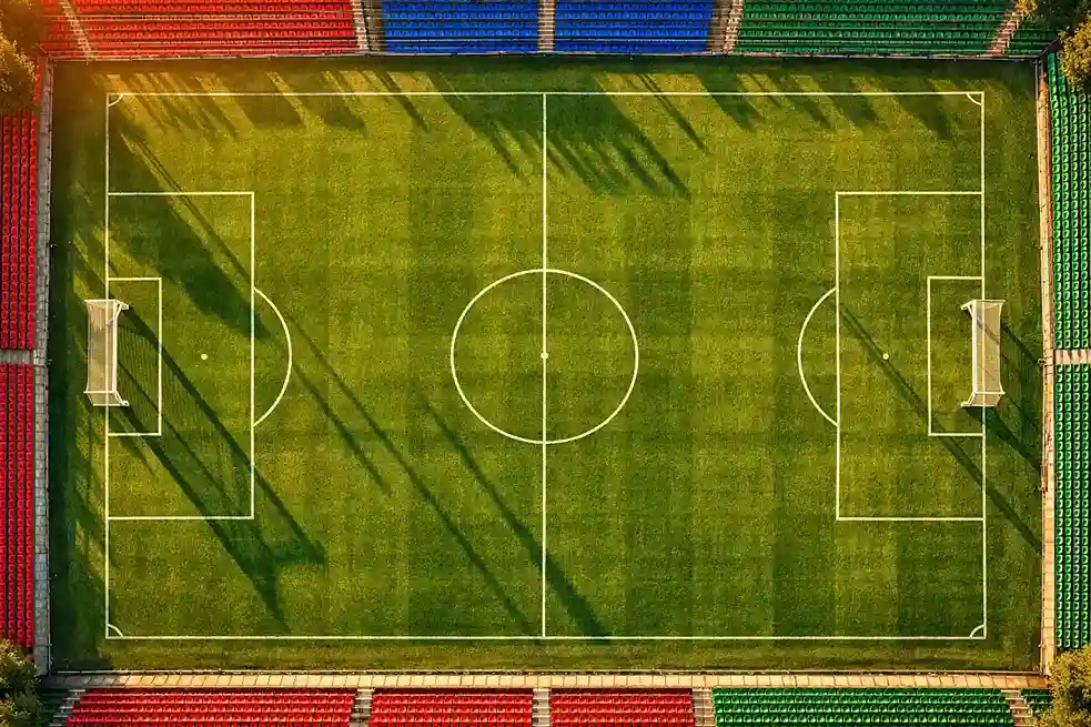 Trois terrains de football symbolisant la Premier League, la Liga et la Série A vus du ciel
